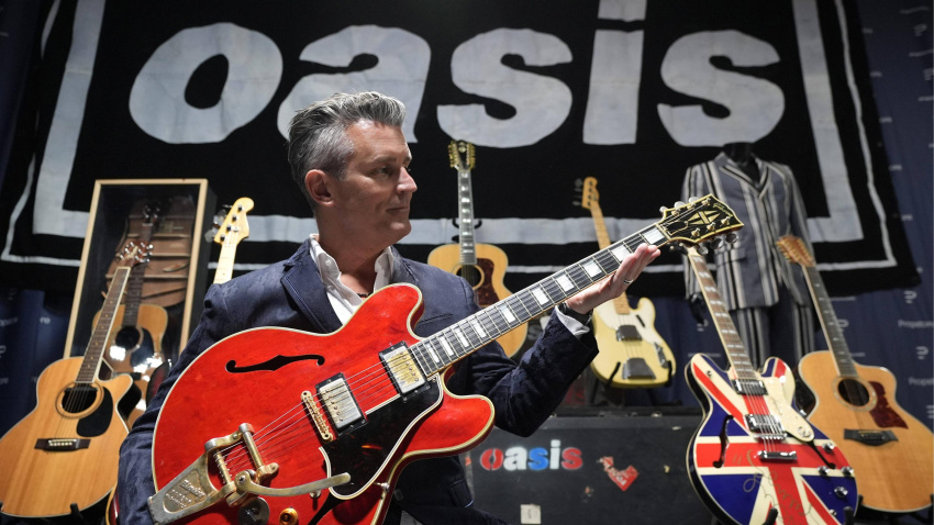 Propstore CEO Stephen Lane, holds Noel Gallagher's 1960 cherry red Gibson ES-355 guitar, damaged in Paris by Liam Gallagher on the night Oasis broke up and since repaired, with an estimate of £250,000 - £500,000, during a preview for the upcoming music memorabilia auction, taking place in London from October 23-24. Picture date: Tuesday September 16, 2025.