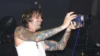 RMWYN0 Musician Tommy Lee, founding member and drummer of the heavy metal band Motley Crue, is shown performing on stage during a concert with his solo project.