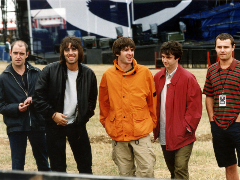 G468KF OASIS ENJOY A LAUGH BEFORE THEIR KNEBWORTH PARK CONCERT. L/R RHYTHM GUITARIST PAUL "BONEHEAD" ARTHURS, LEAD SINGER LIAM GALLAGHER, GUITARIST & SONGWRITER NOEL GALLAGHER, BASS PLAYER PAUL "GUIGSY" MCGUIGAN & DRUMMER ALAN WHITE. * Reissued 24/2/99 - Arthurs, 33, was picked up by police after shouting and swearing outside a glitzy fashion party in London it emerged. He spent several hours in the cells before receiving a formal warning for being drunk and disorderly, but he was not charged. * 9/8/99: Guitarist Paul 'Bonehead' Arthurs has quit the band after eight years.