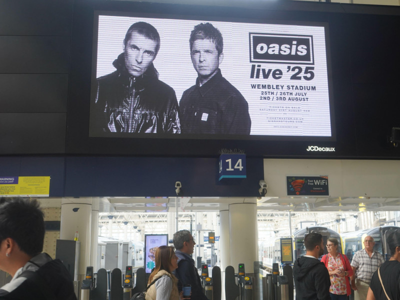 2XY63HH Waterloo, London. 28 August 2024. A digital board at Waterloo station with the brothers Liam and Noel Gallagher , as the Manchester band Oasis announce they are due to reunite after 15 years with a series of concerts dates in 2025 including at Wembley stadium Credit: Amer Ghazzal/Alamy Live News
