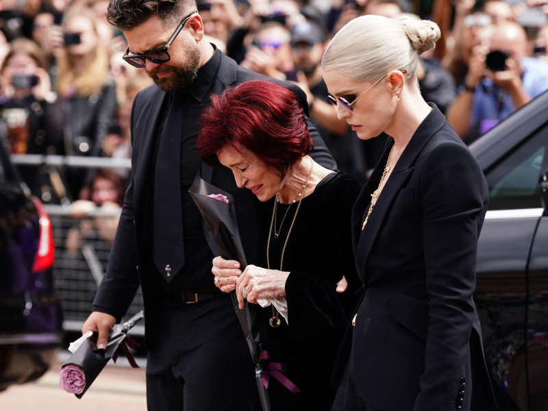 3C5FX5N The family of Ozzy Osbourne (left to right) Jack Osbourne, Sharon Osbourne and Kelly Osbourne lay flowers and view the messages and floral tributes left at the Black Sabbath Bridge bench on Broad Street in Birmingham in memory of Black Sabbath frontman Ozzy Osbourne, as his body is brought back to his home city for a procession following his death last week aged 76. Picture date: Wednesday July 30, 2025.