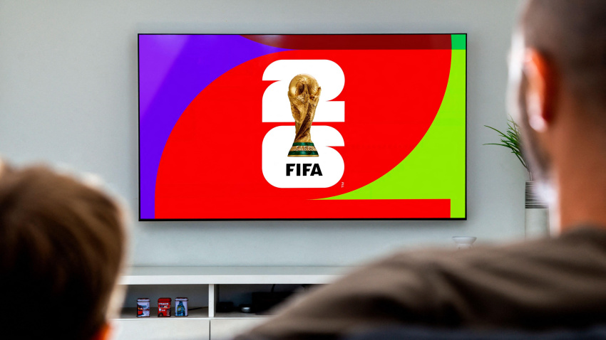 3AKR2GD Man and his son looking a smart TV with the FIFA World Cup 2026 the screen. Rosario, Argentina - April 12, 2025.