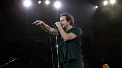 G1B60T Eddie Vedder, lead singer of Pearl Jam standing a the microphone, pointing to the crowd while performing at the Air Canada Centre, Toronto